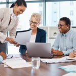Team members gathered in a meeting room, focused on discussion with materials in front of them, representing efficient meeting practices