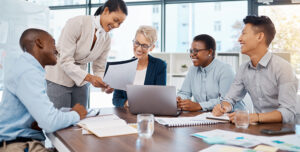 Team members gathered in a meeting room, focused on discussion with materials in front of them, representing efficient meeting practices